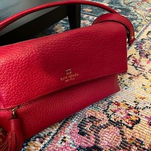 Shoulder length red Kate Spade medium-sized purse, with gold embellishments